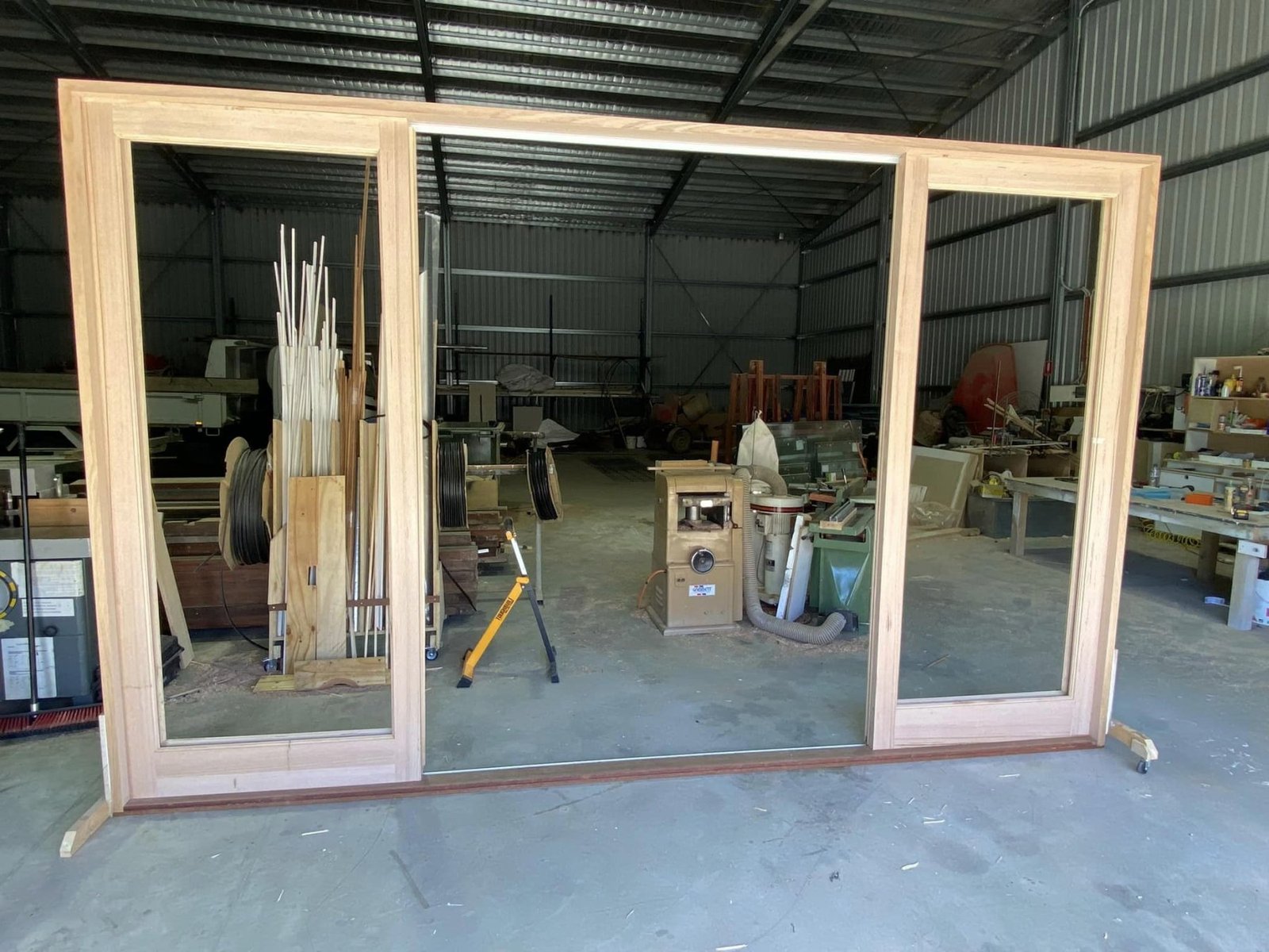 Timber-framed double sliding door unit assembled in the workshop, ready for glazing