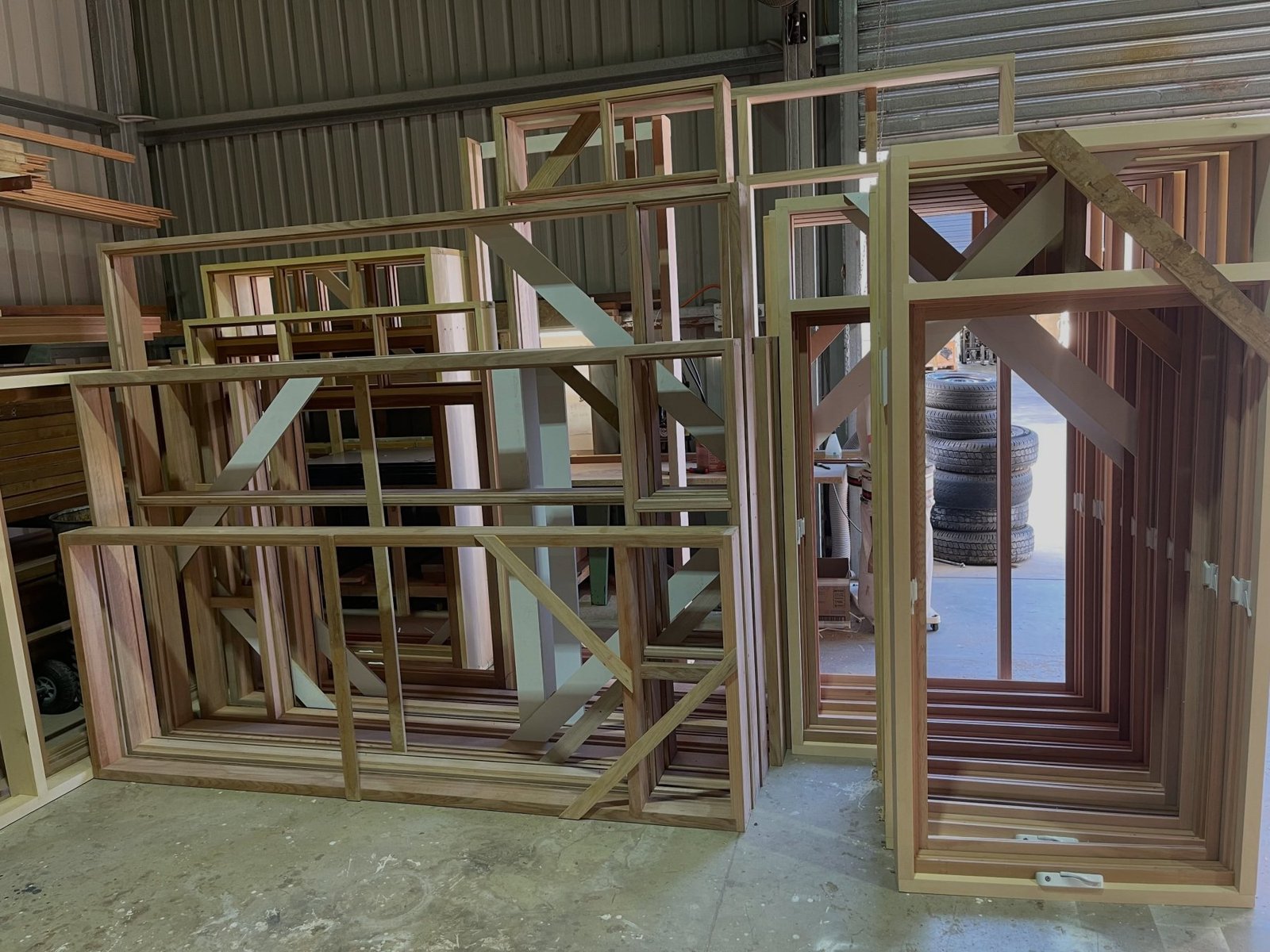 Multiple timber window and door frames stacked and arranged in the workshop