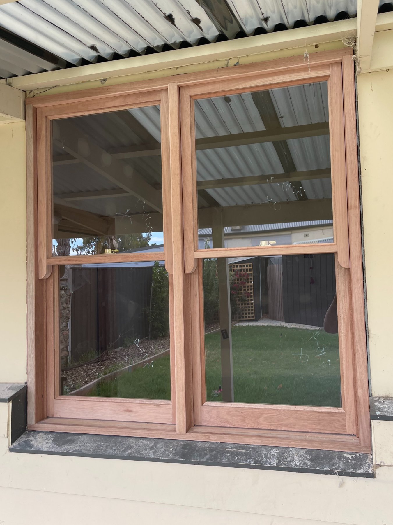 Pair of timber double-hung sash windows installed under a patio roof