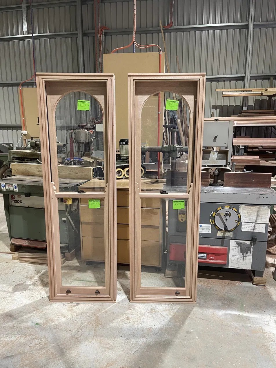 Pair of arched-top timber sash windows finished in the workshop, ready for install