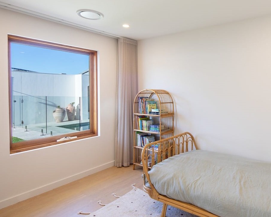 Fixed timber-framed window overlooking the pool, bedroom interior