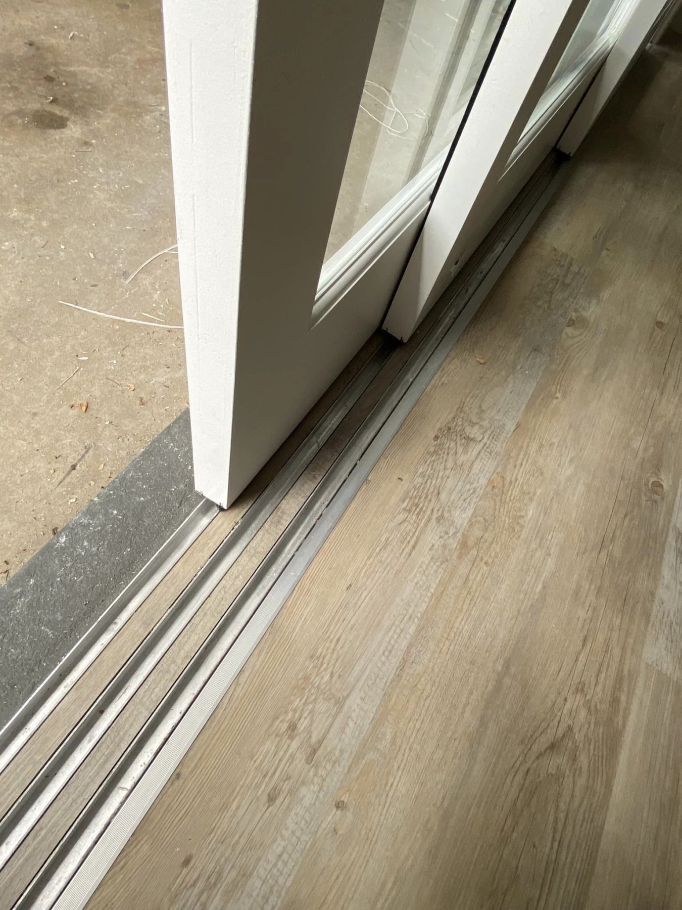Close-up of a sliding door's bottom track and rollers
