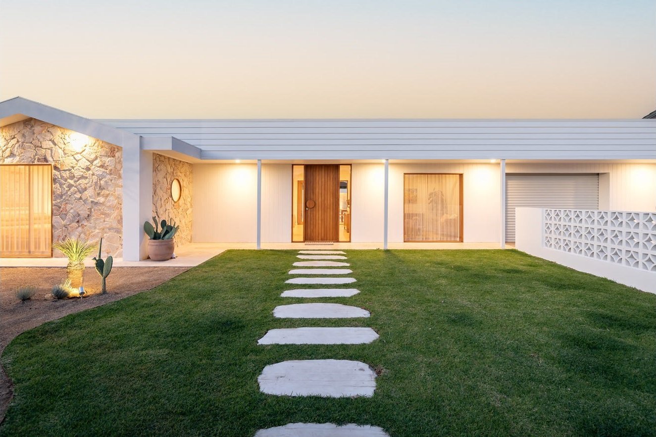 Modern home facade with a central timber entry door and round feature window