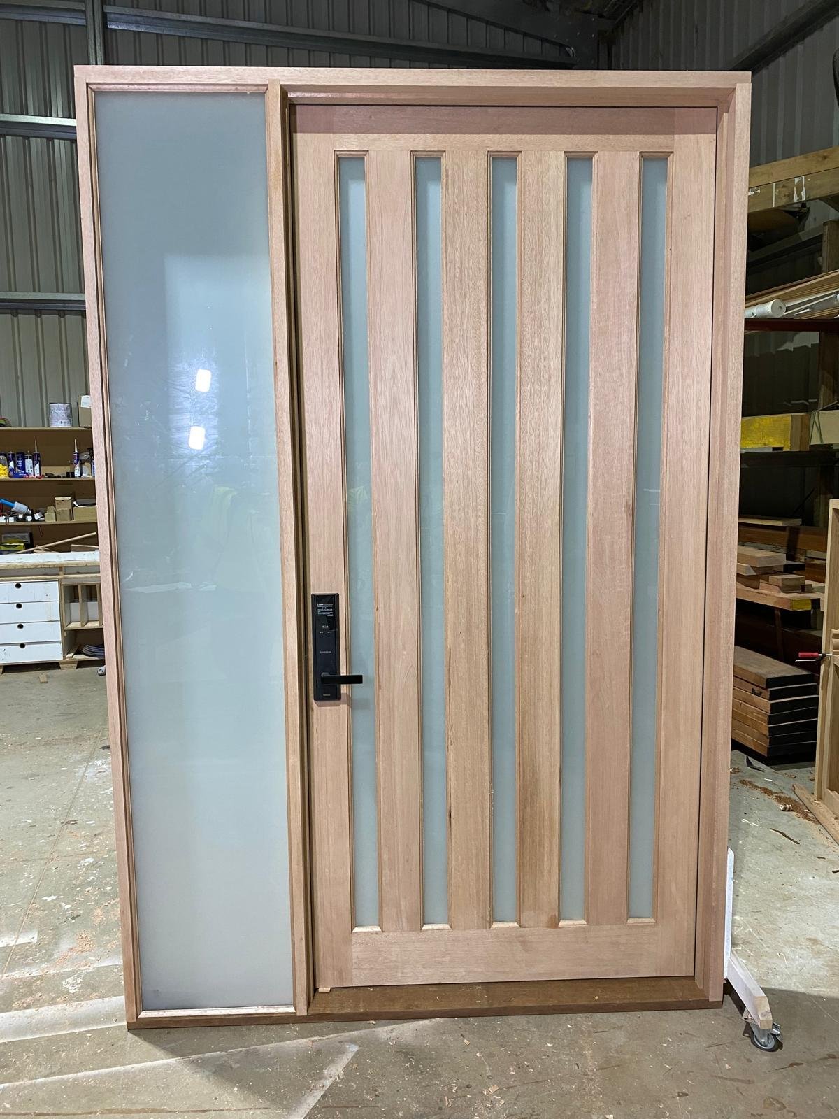 Five-panel timber entry door with frosted glass inserts and matching sidelight, workshop