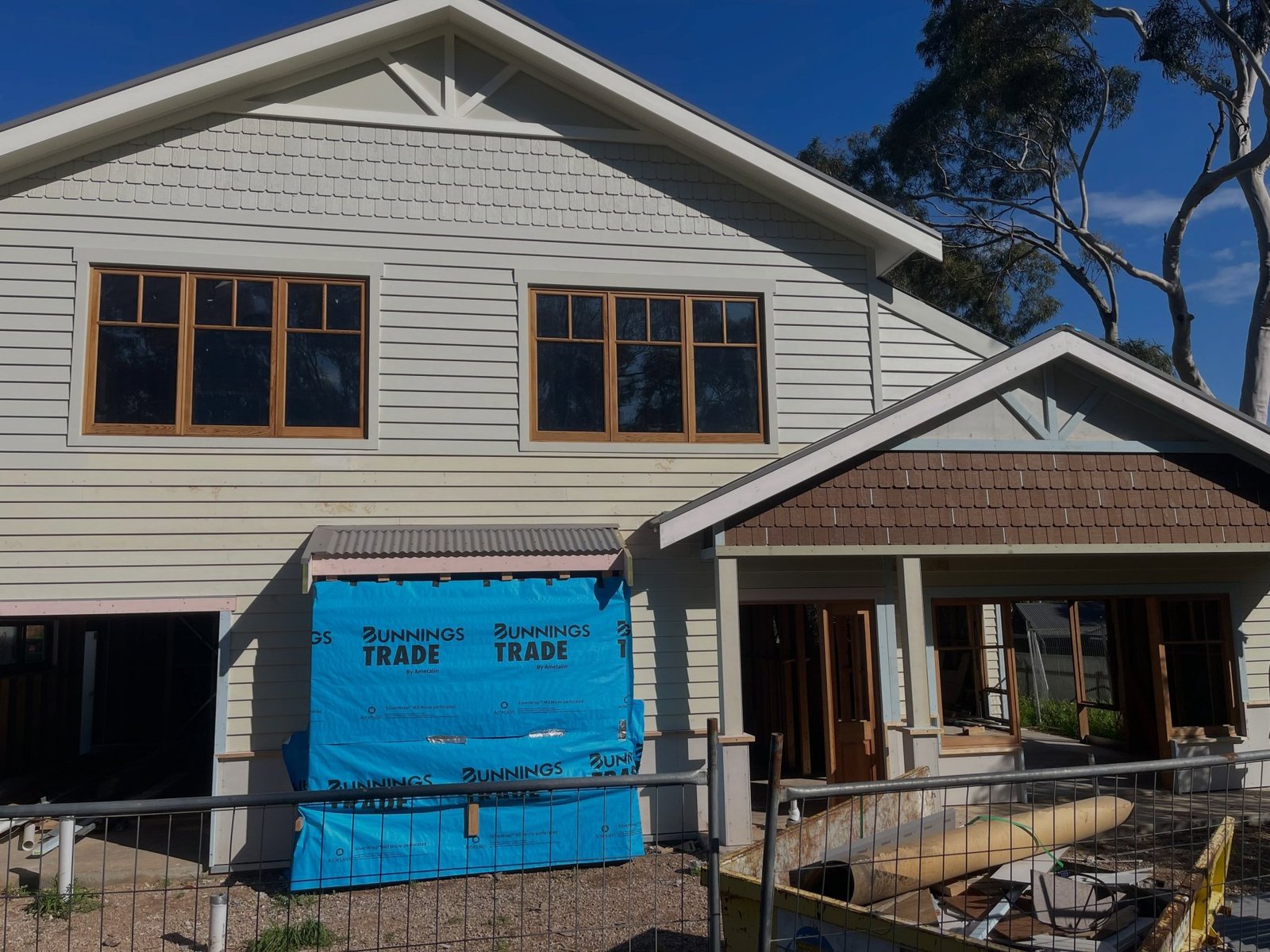 Timber-framed windows on a two-storey home under construction, weatherboard cladding