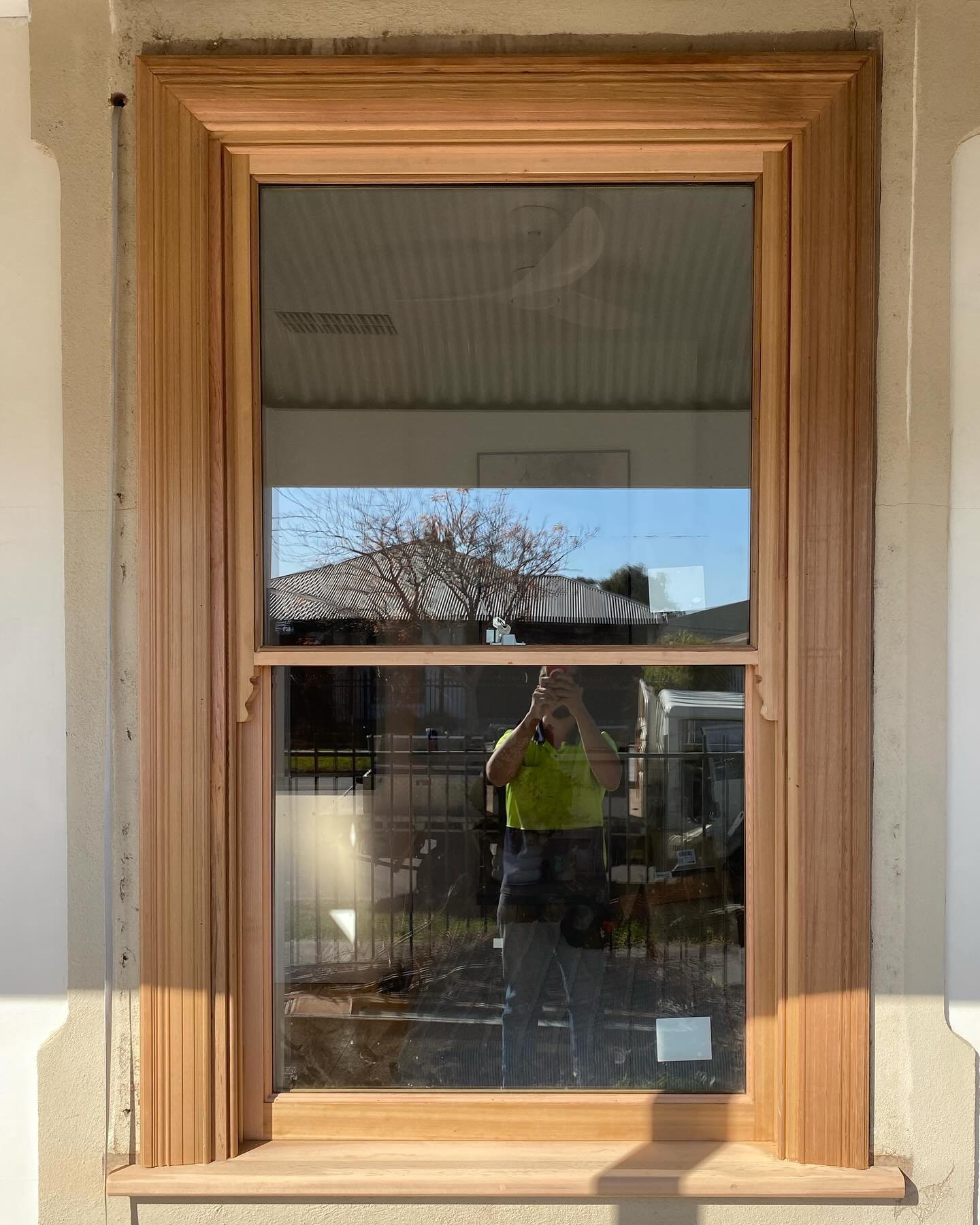 Timber double-hung sash window with decorative trim, installed on a rendered home exterior