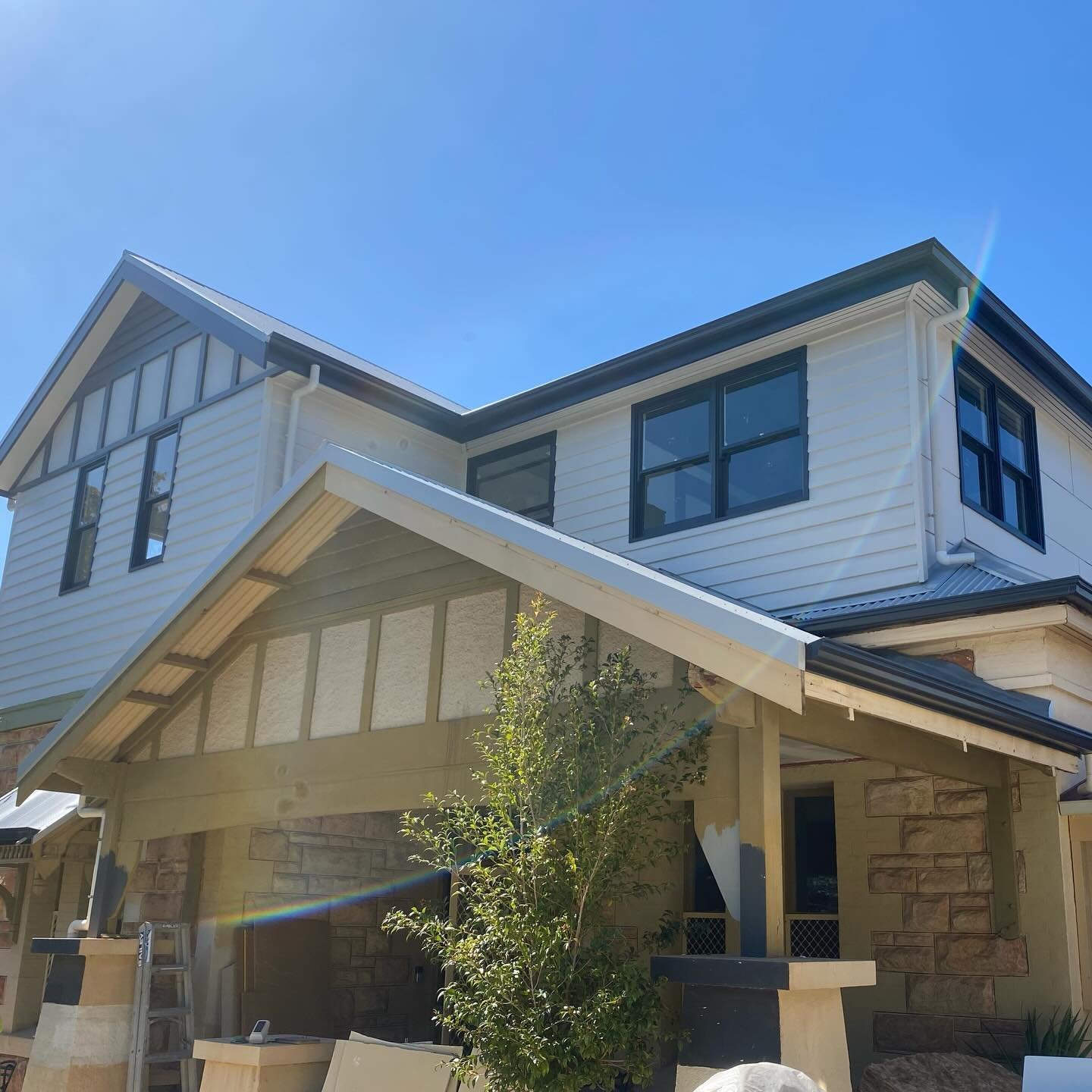 Black-framed timber double-hung windows on a two-storey home exterior