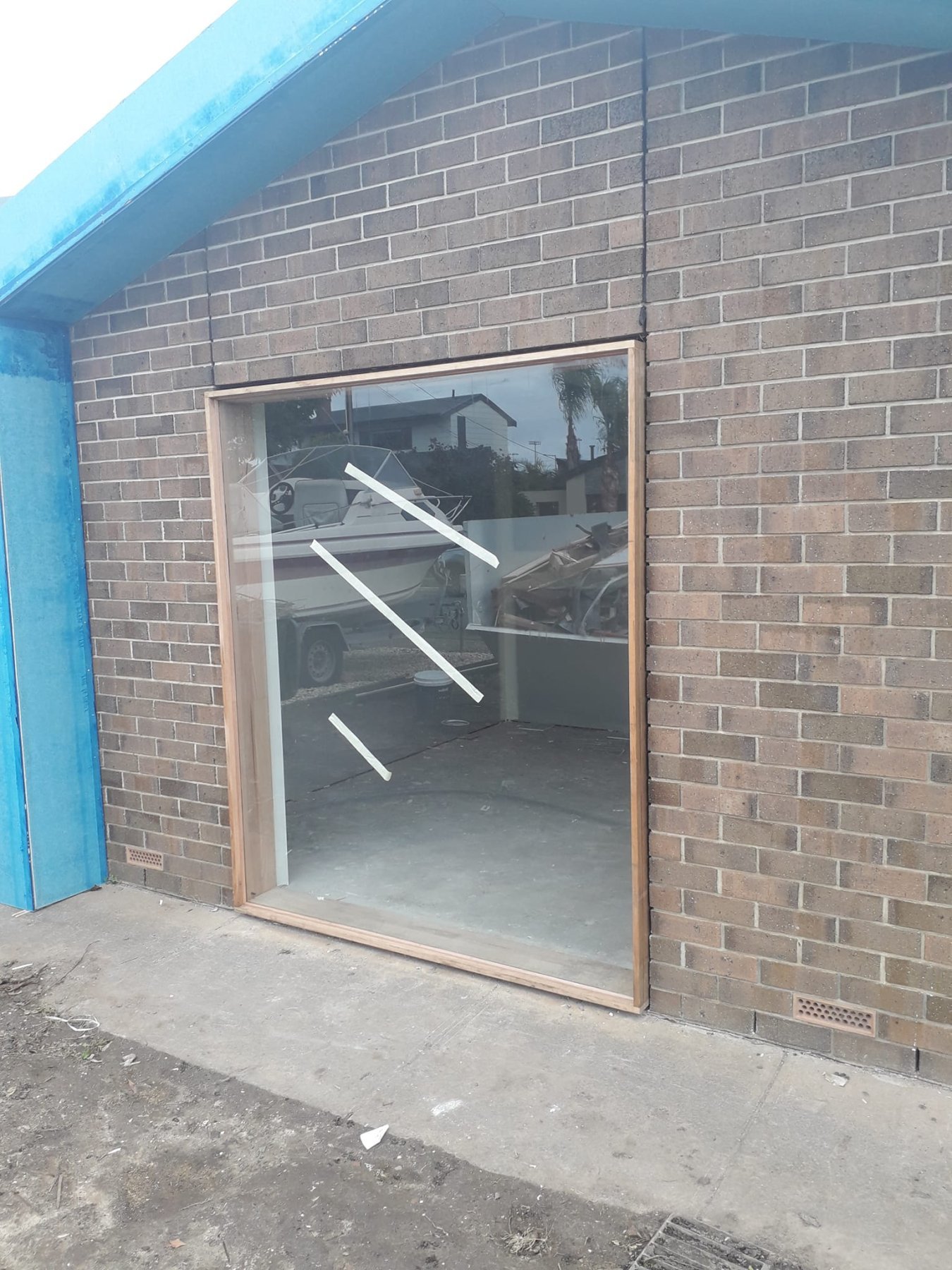 Large Vic Ash fixed-glass window panel installed in a commercial brick building